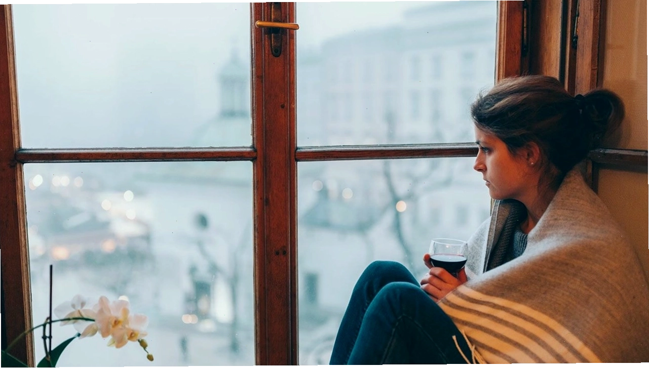 Người phụ nữ ngồi một mình với biểu cảm mệt mỏi, u sầu